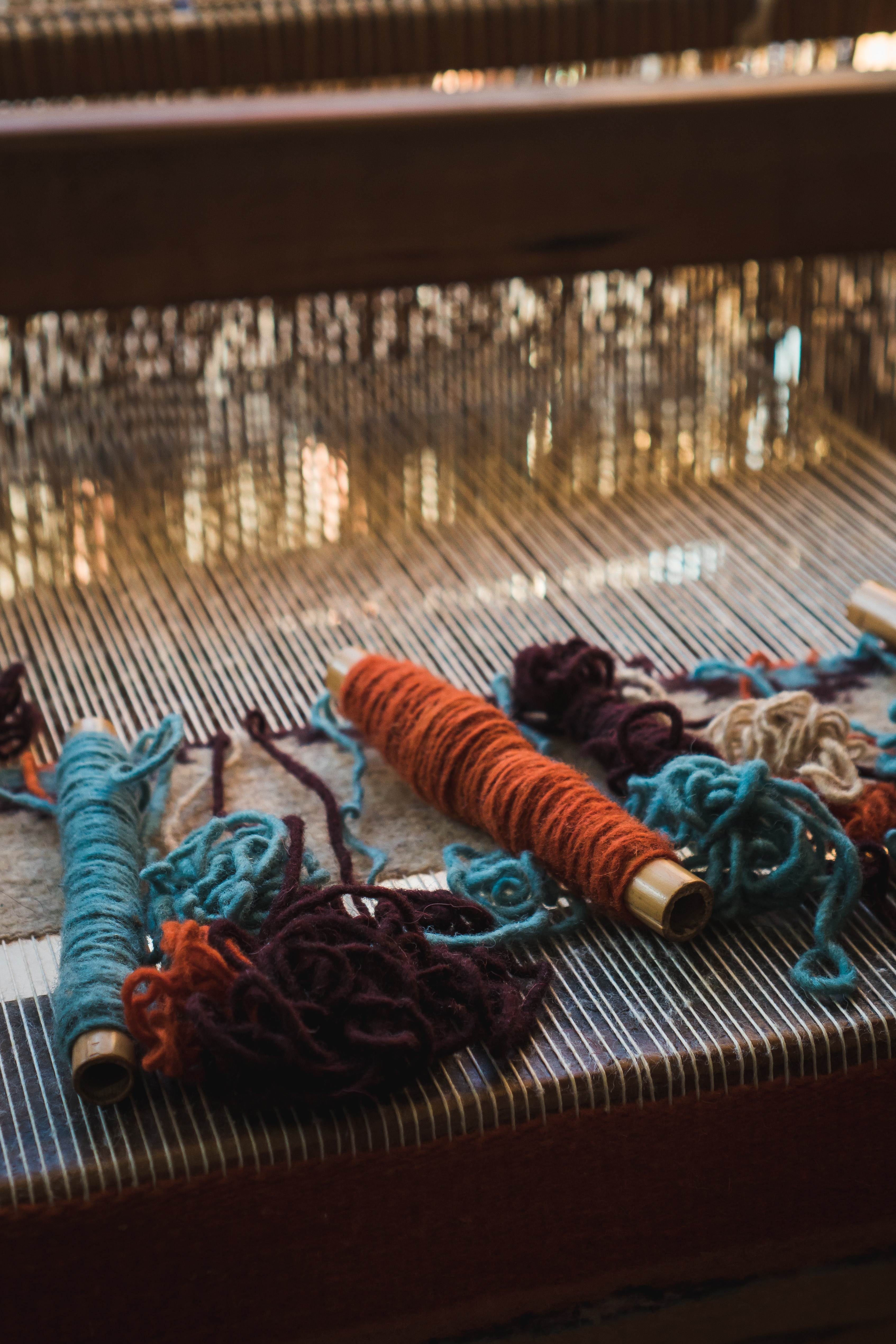 close-up of colorful yarn bobbins on a loom